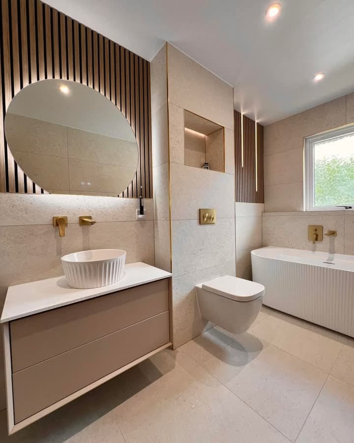 Hey, peek at this chic bathroom! Electrical updates & fittings shine with modern lights and outlets, highlighting a sleek vanity and tub. Wood accents add warmth—perfect for a stylish upgrade!