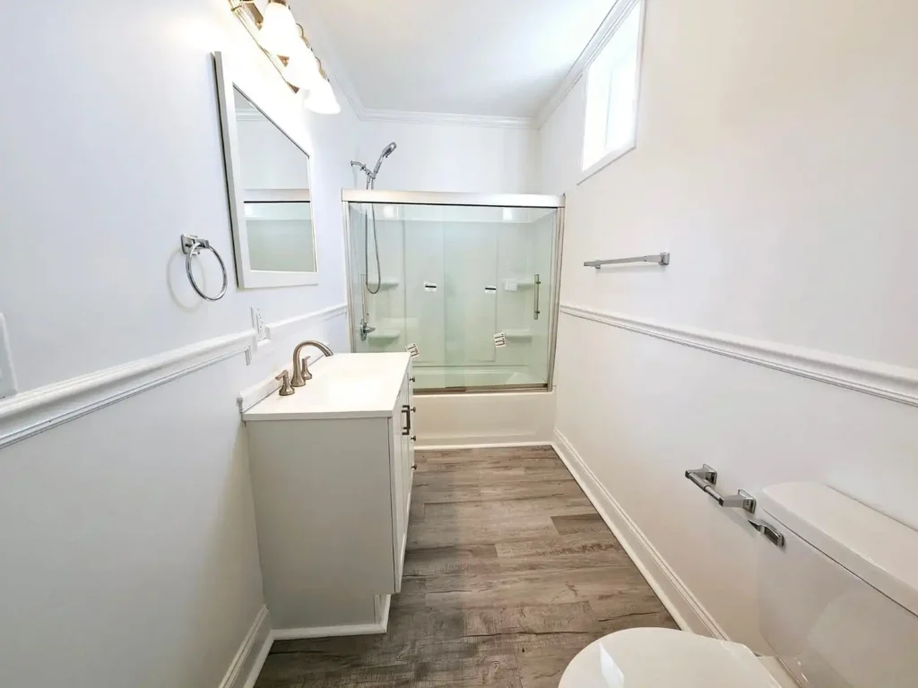 Yo, check out this upgraded Conroe bathroom! Bright vanity lights and safe outlets shine over the sleek vanity, glass shower, and wood floors. Our pros bring top-notch electrical updates to life!
