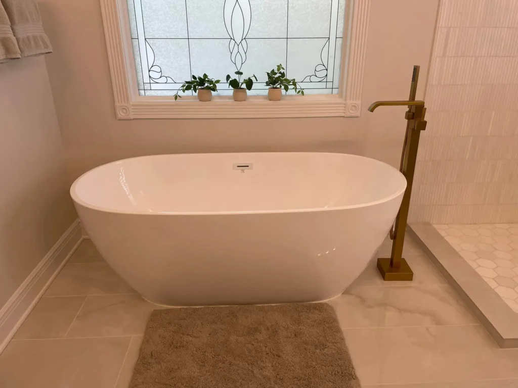Elegant bathroom featuring a new Whirlpool Tub Installation, accented by a stained-glass window with plants, a plush rug, and a gold faucet.